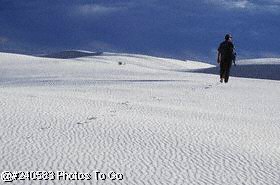 Hombre caminando en dunas de arena